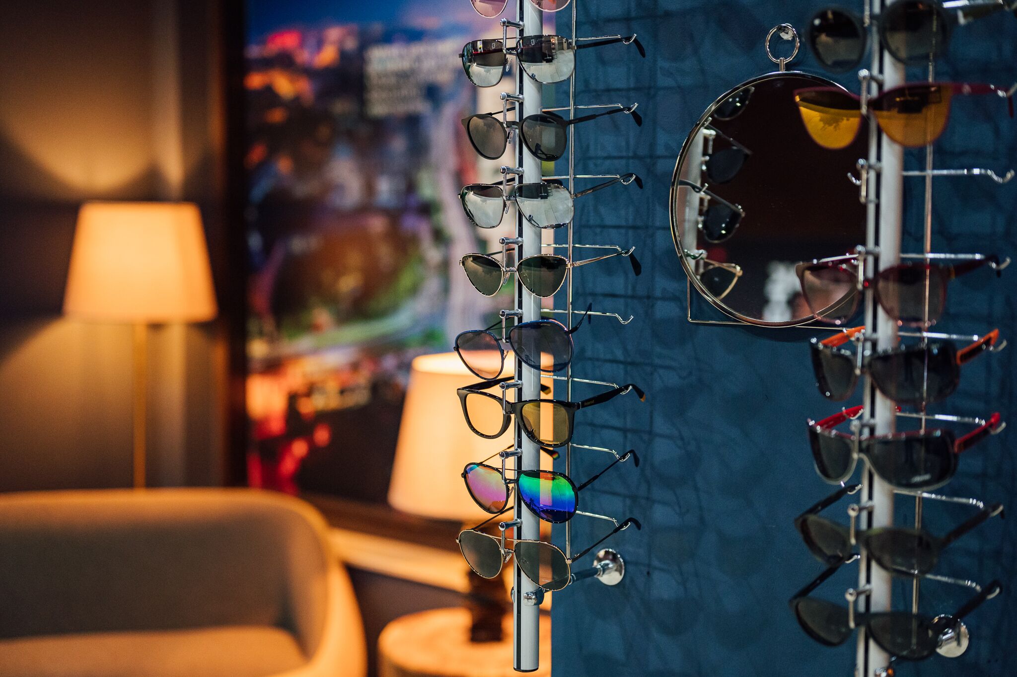 A display of eyeglasses on a stand in a room with a lamp and a chair.