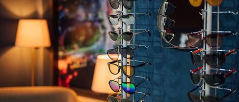 A display of eyeglasses on a stand in a room with a lamp and a chair.