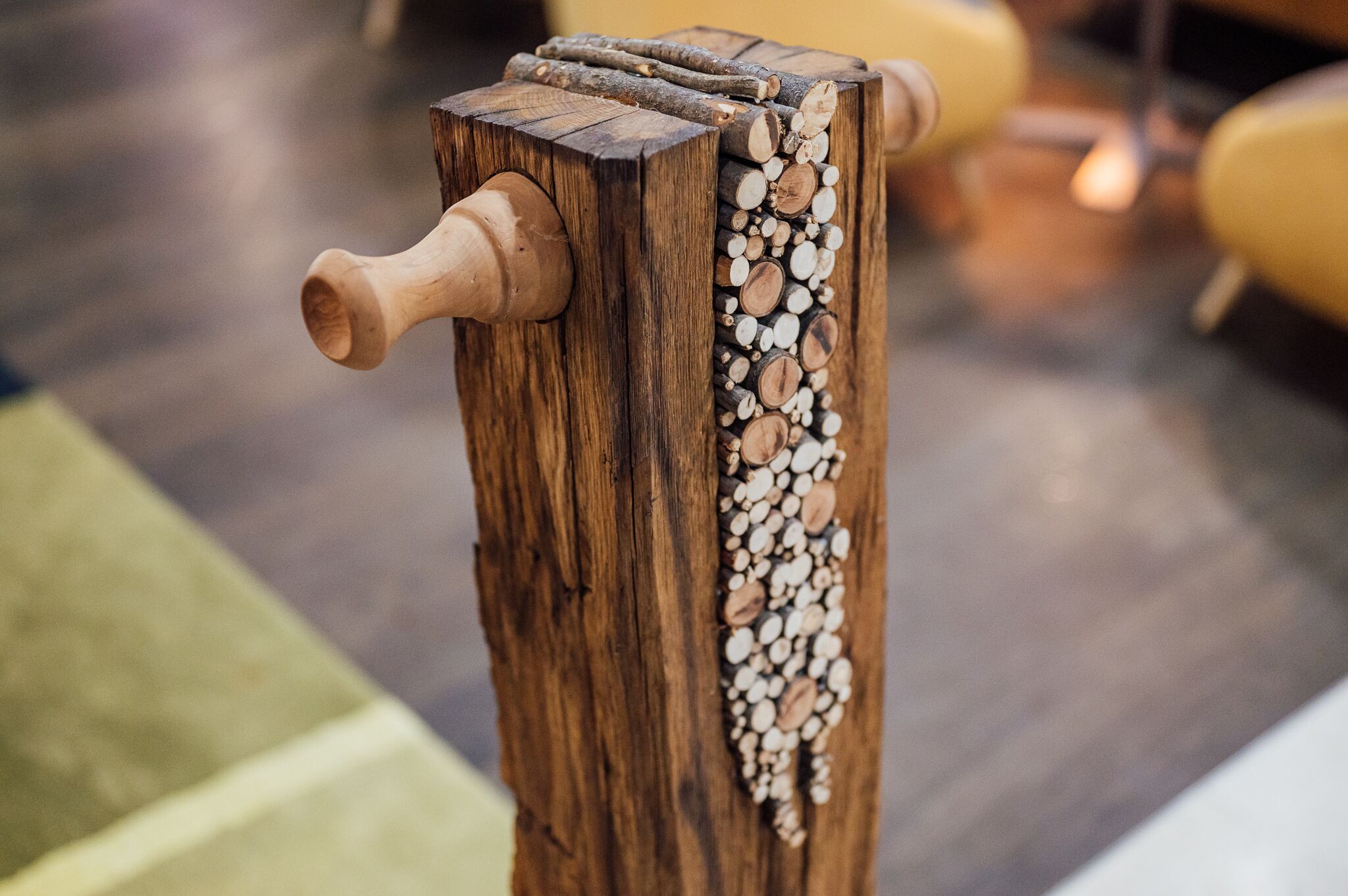 Una estructura de madera con un asa tallada y una pila de leña.
