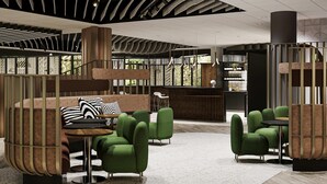 A modern interior with green upholstered chairs, a wooden bench, and a striped pillow.