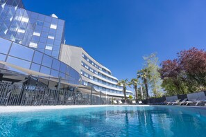 Alberca al aire libre, sombrillas en la alberca y camastros 