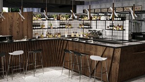 A modern bar area with a wooden counter, bar stools, and shelves stocked with bottles.