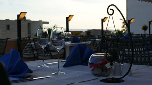 Una mesa lista para comer con copas de vino, salero y pimentero, y un candelabro.