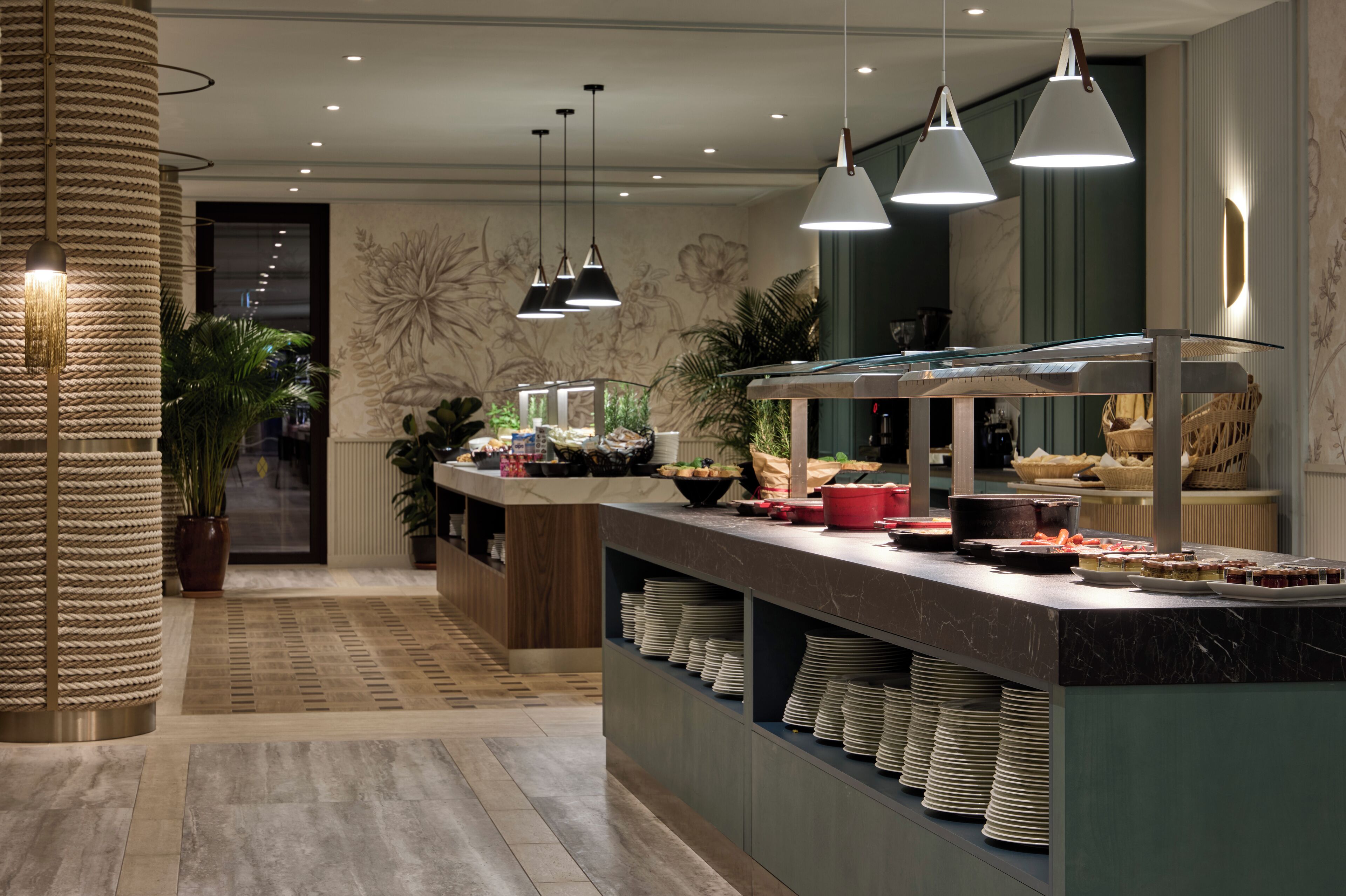 A buffet setup with a marble counter, hanging pendant lights, and a patterned wall.