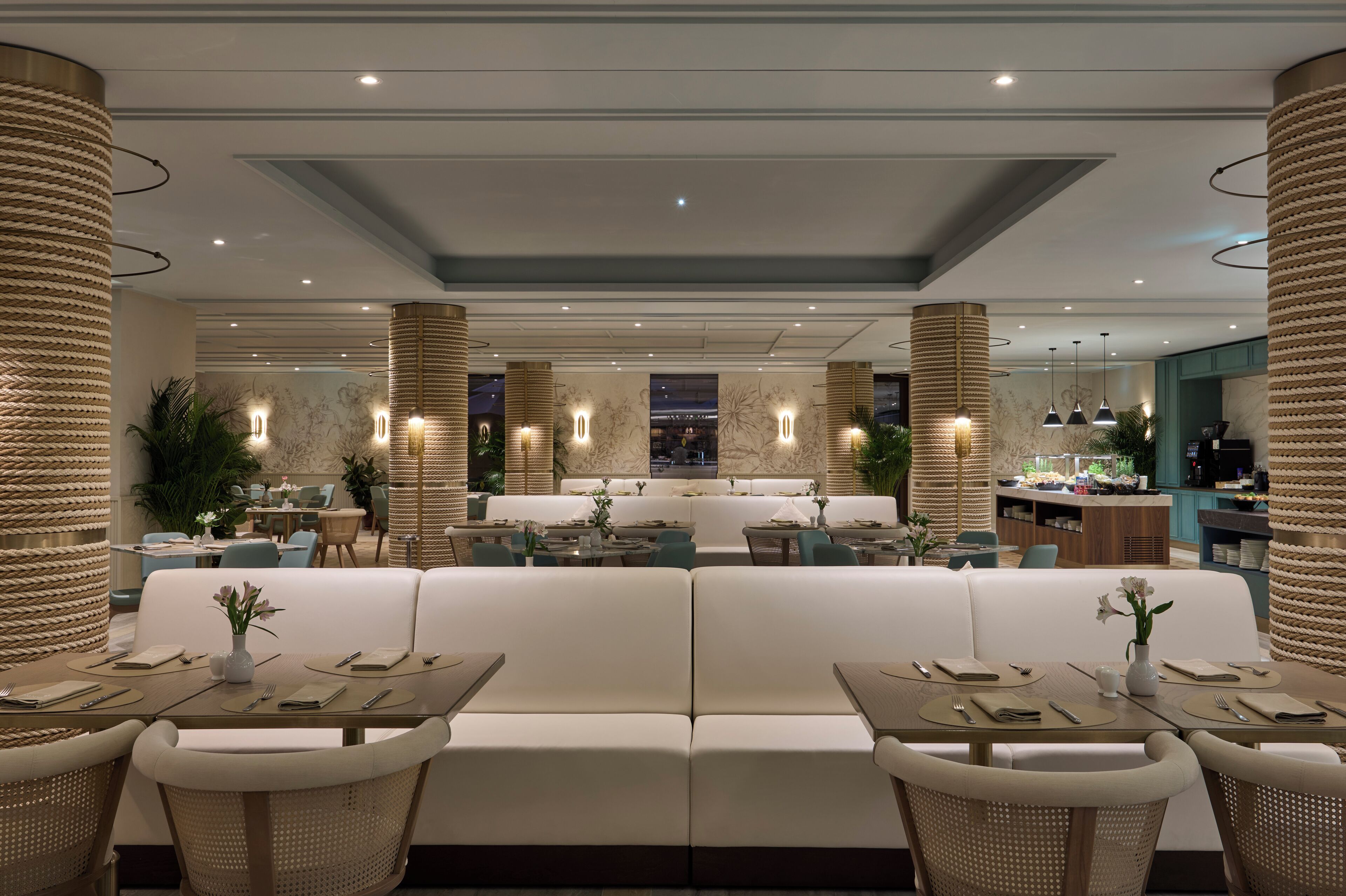 A modern restaurant with a central seating area, multiple tables, and a bar.