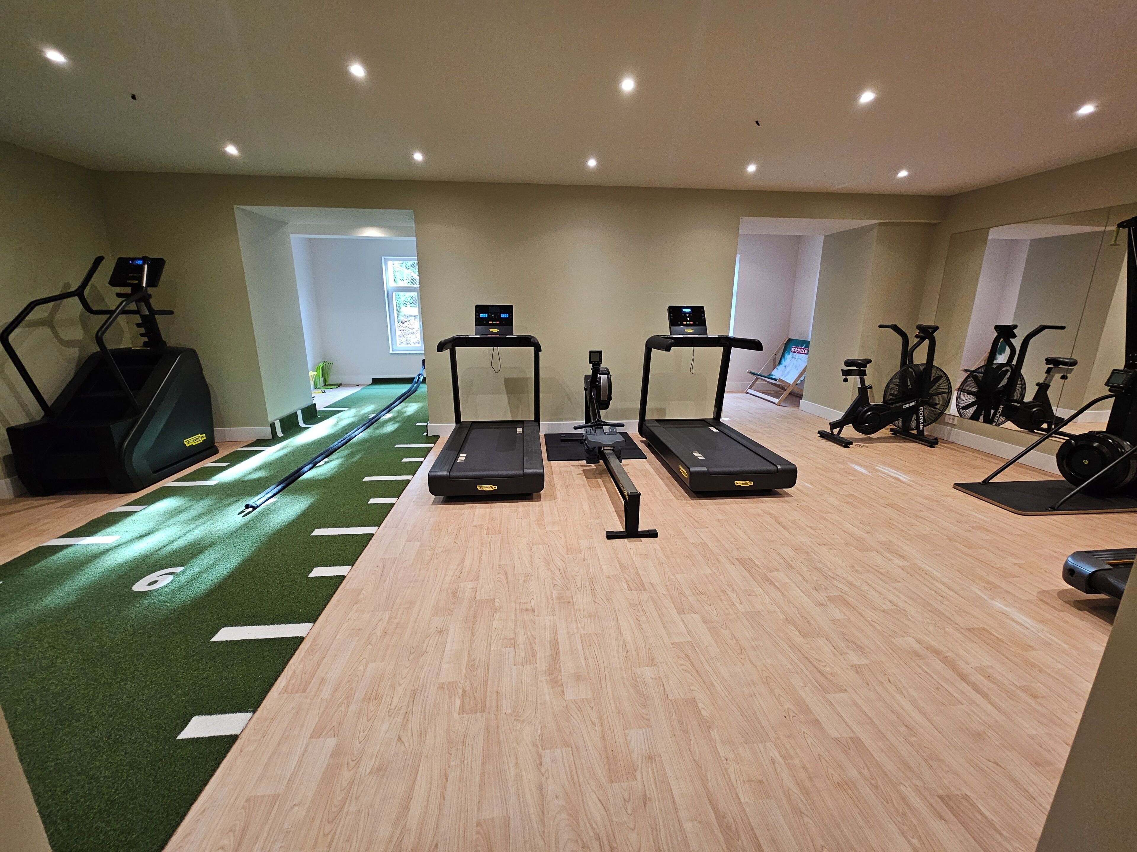 A gym with treadmills, stationary bikes, and a rowing machine.