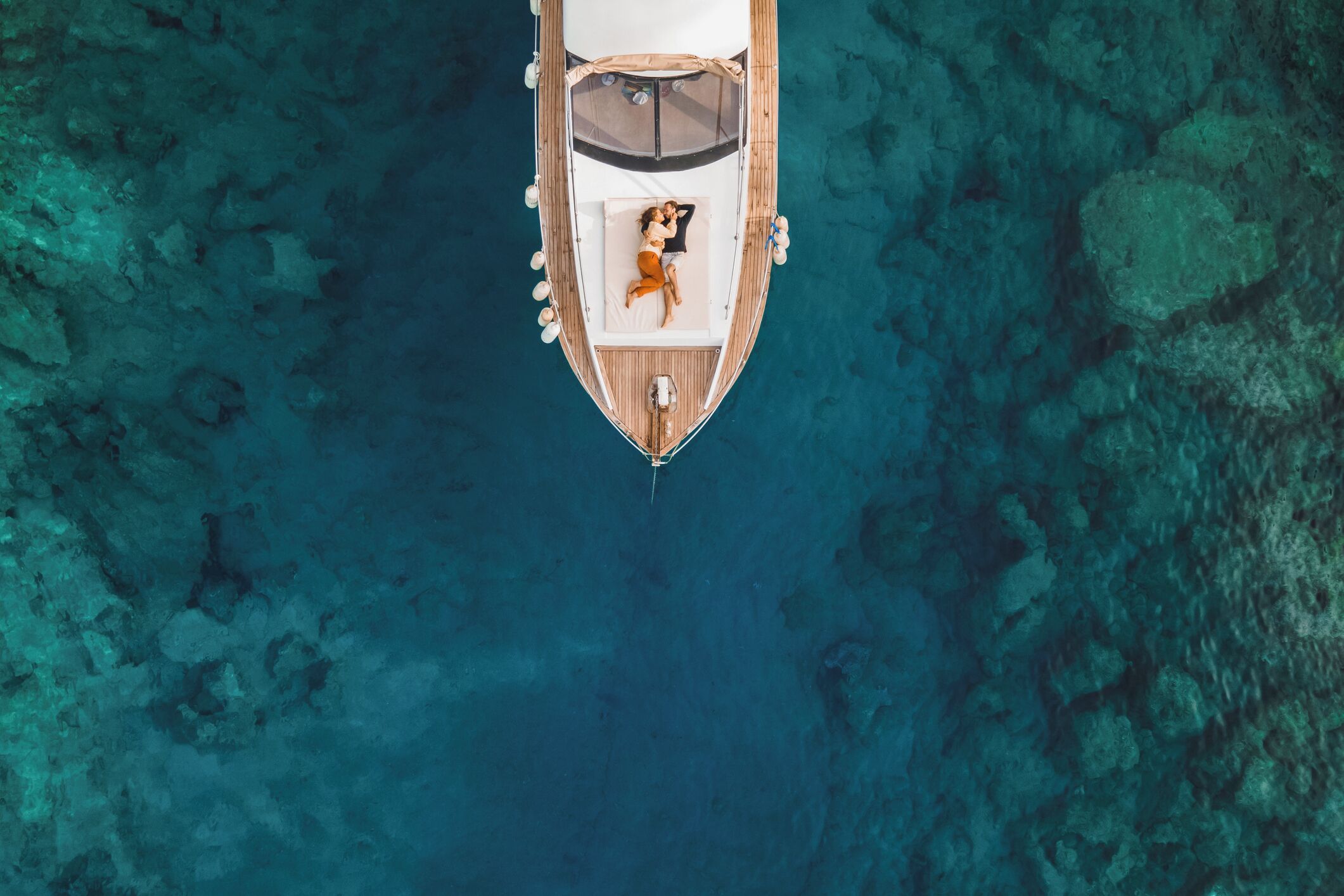 Vista aérea de un barco con cubierta techada y una persona recostada en una silla de descanso.