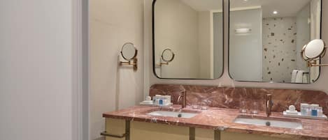 A bathroom with two sinks, a large mirror, and a towel rack.