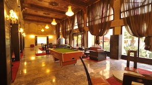 A spacious indoor area with a pool table, comfortable seating, and large windows. - El Andalous Lounge & Spa Hotel (Marrakech)