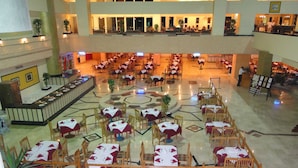 A spacious hotel lobby with multiple dining areas, a central fountain, and a high ceiling. - Sharm Holiday Resort (Sharm El Sheikh)