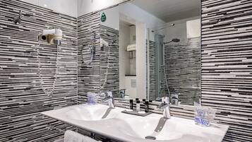 Un baño moderno con dos lavamanos, un espejo grande y una ducha.