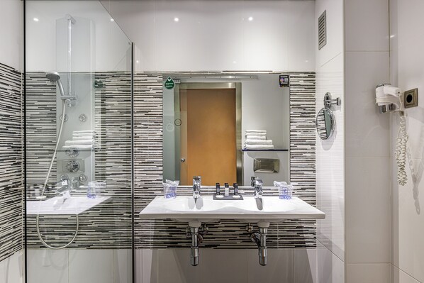 A modern bathroom with a glass-enclosed shower, two sinks, and a mirror. - Hotel Ronda Lesseps (Barcelona)