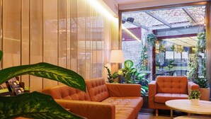 A modern interior with a leather sofa, a round table, and potted plants.