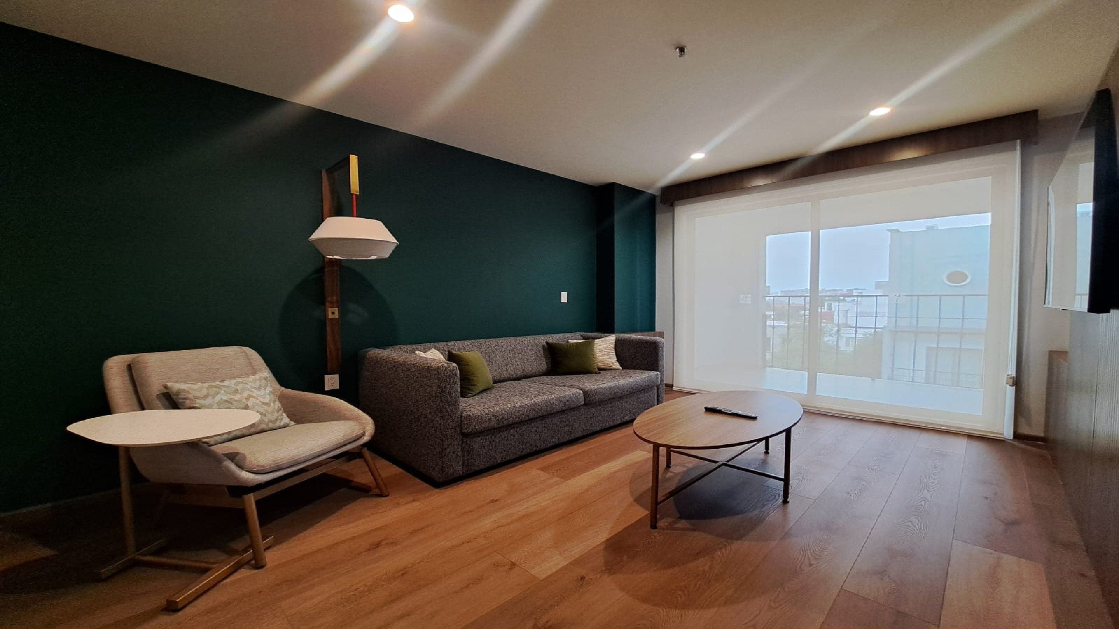 A modern living room with a sofa, armchair, and a small table.