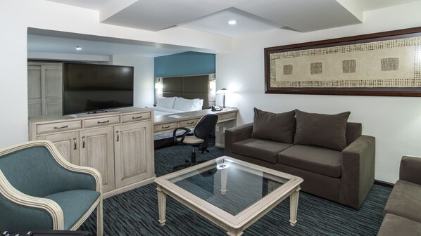 A hotel room with a bed, desk, chair, sofa, and a television. - Holiday Inn & Suites Mexico Zona Reforma by IHG (Mexico City)