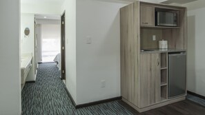 A hotel room with a kitchenette, a microwave, a refrigerator, and a bathroom with a mirror and toilet. - Holiday Inn & Suites Mexico Zona Reforma by IHG (Mexico City)