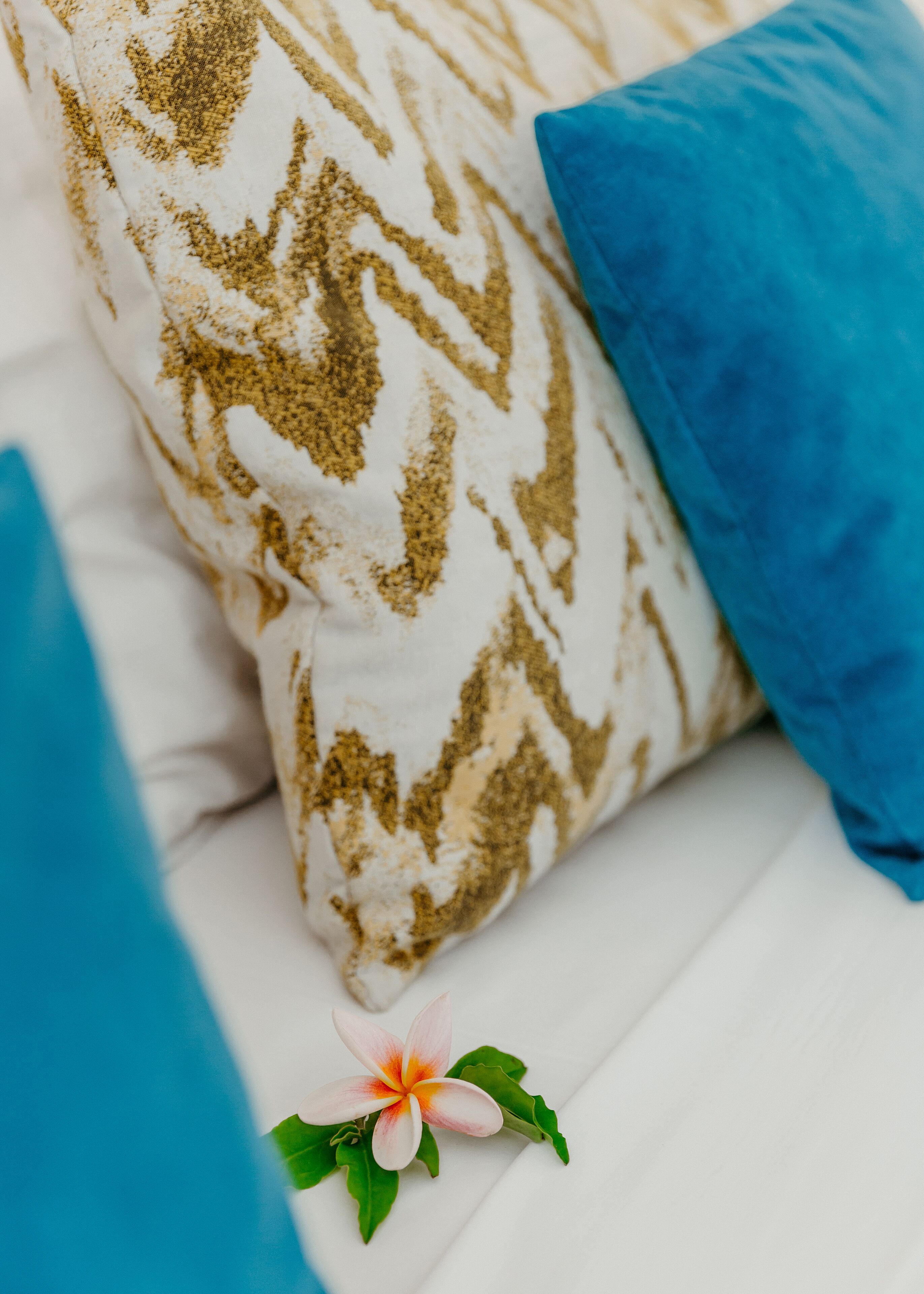 A bed with white bedding and a patterned pillow.