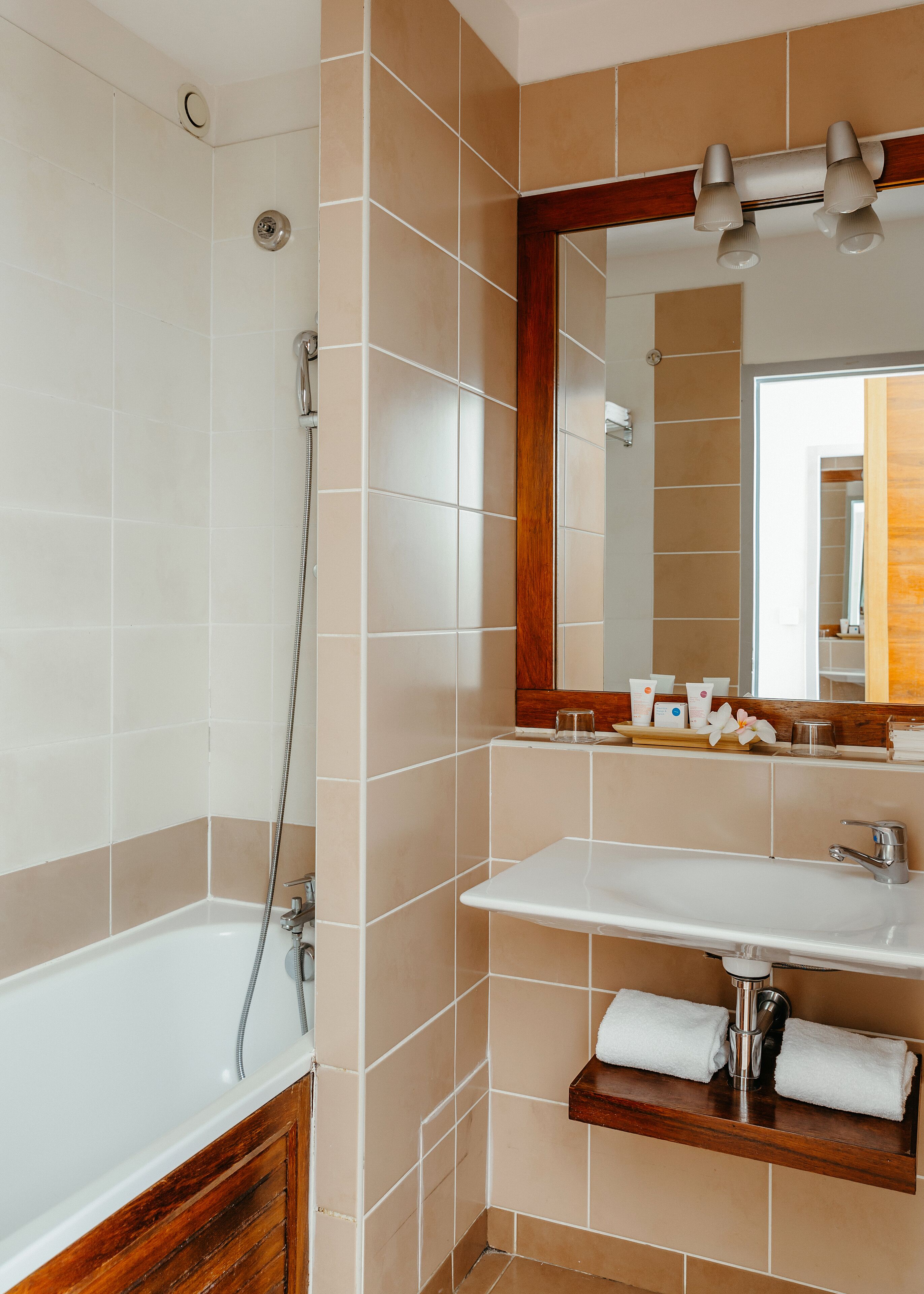 A bathroom with a bathtub, a sink, and a mirror.