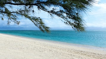 On the beach, white sand, sun loungers, beach umbrellas