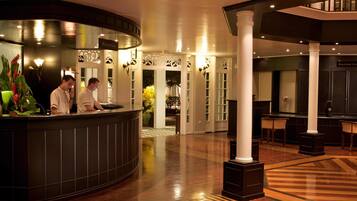 A reception area with a curved counter, two receptionists, and a reception sign.