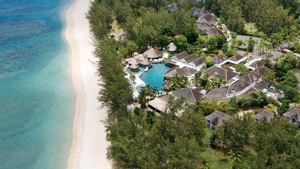 An aerial view of a resort with a beachfront, a swimming pool, and multiple bungalow-style buildings. - LUX* Saint Gilles (Saint-Paul)