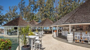 A resort with outdoor seating, a pool, and a bar area. - LUX* Saint Gilles (Saint-Paul)