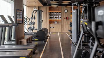 A gym with treadmills, elliptical machines, and weightlifting equipment.