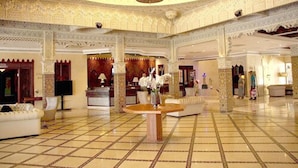 A spacious lobby with intricate tile flooring, a central round table, and ornate chandeliers. - Zaki Hotel  (Meknes)