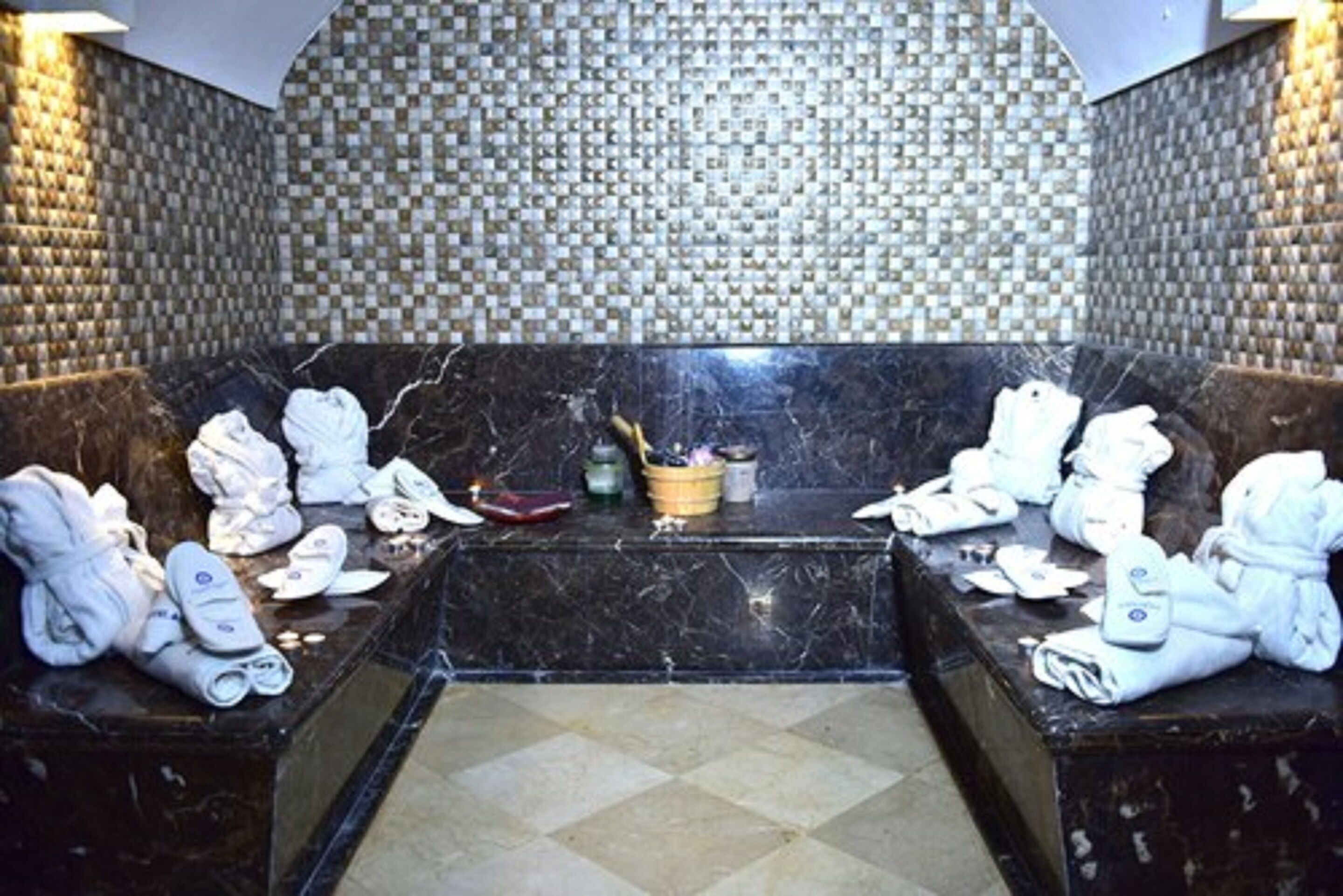 A spa area with two seating areas, each with towels and slippers.