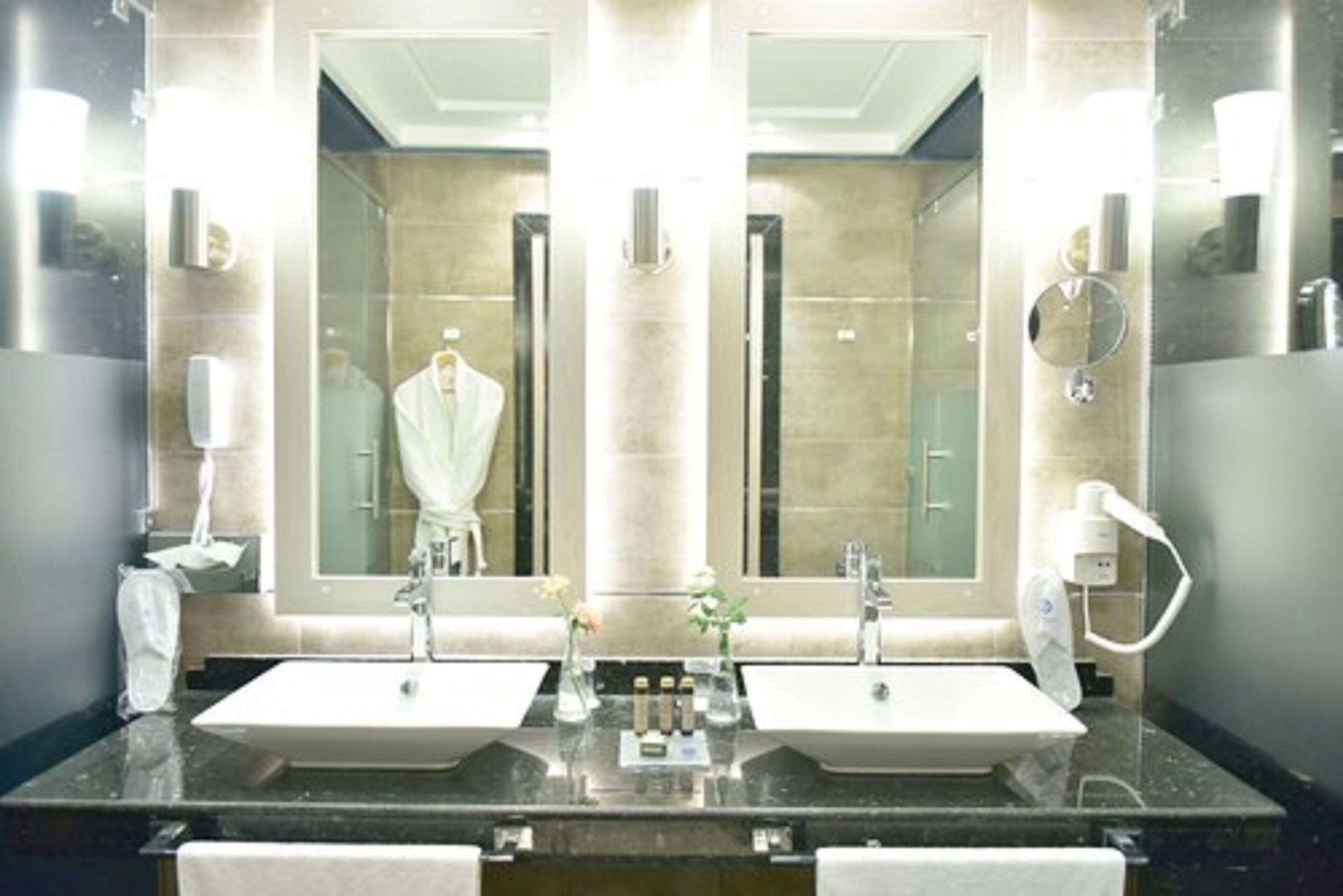 A bathroom with two sinks, a large mirror, and a towel rack.