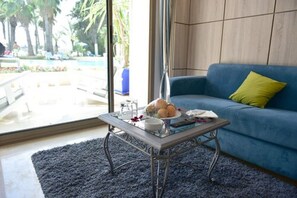 Suite junior, vista a la alberca | Área de sala de estar | Smart TV 