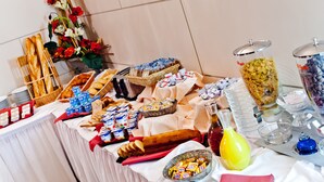 A buffet table with various food items, including bread, pastries, and condiments. - Hotel Continental (Lourdes)