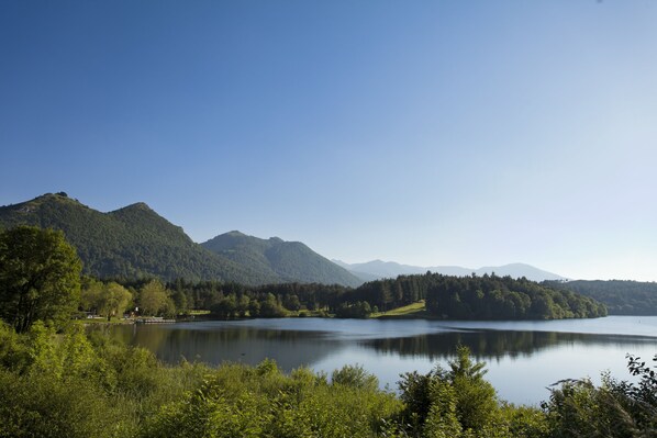 A lake surrounded by mountains and dense forest. - Hotel Continental (Lourdes)