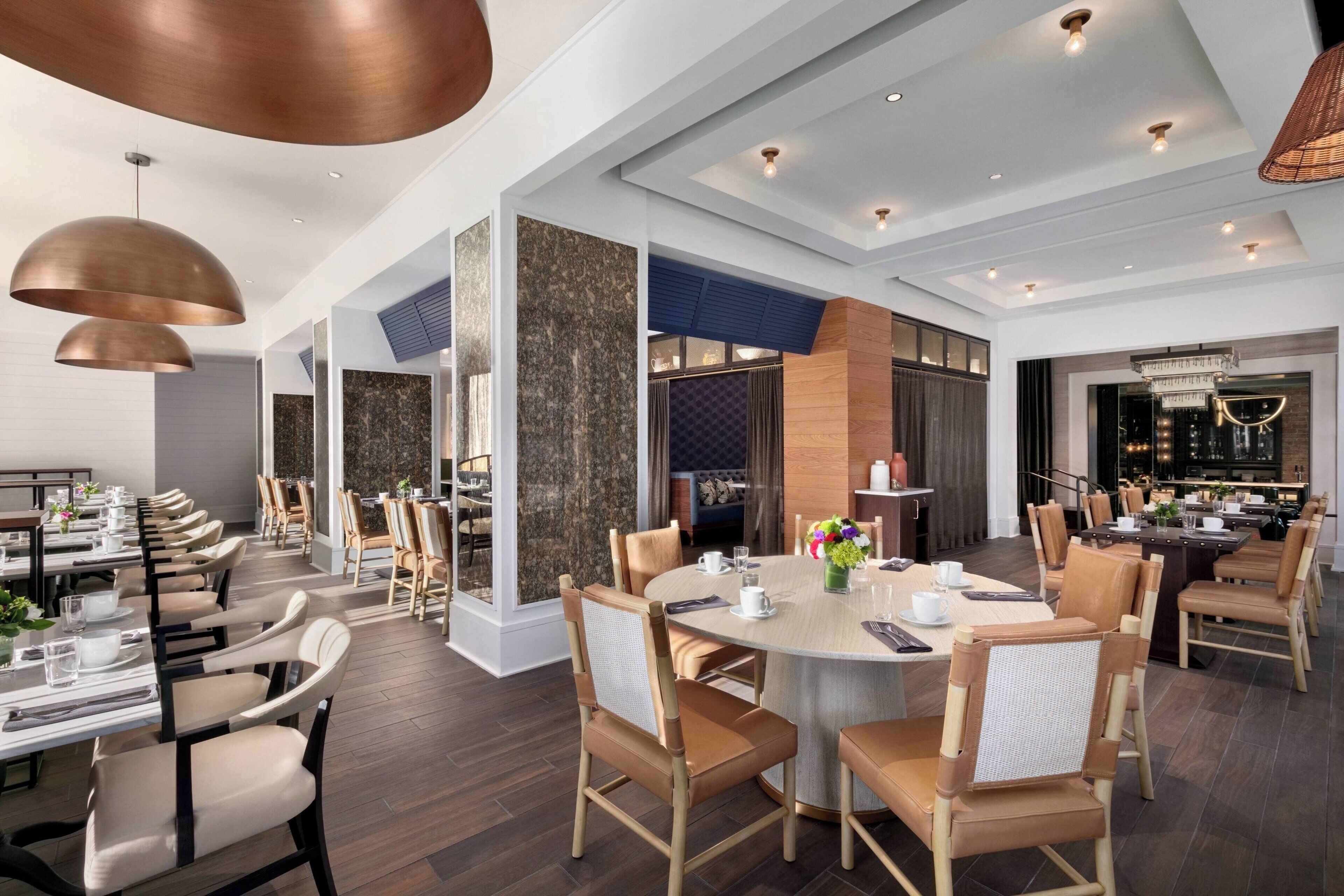 A spacious dining area with multiple tables and chairs, a bar area with seating, and a modern interior design.