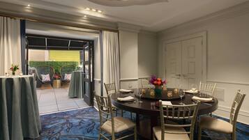 A dining area with a round table, chairs, and a carpeted floor.