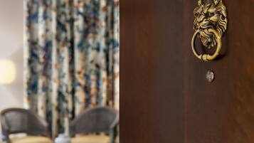 A wooden door with a lion head knocker and a small round knob.