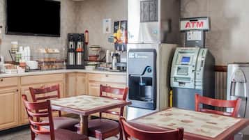 Un restaurante con dispensador automático de bebidas, un cajero automático y una máquina de café.