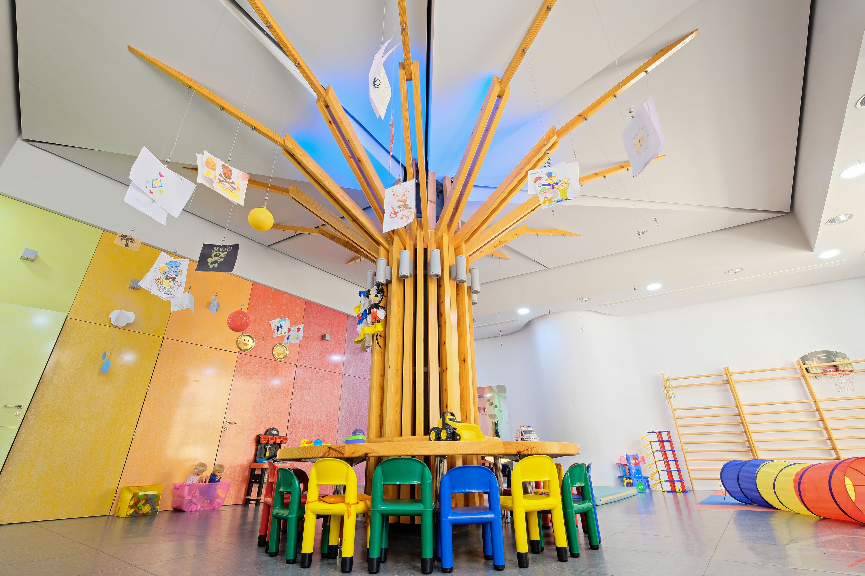 A children's play area with colorful chairs, a table, and a play structure.