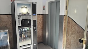 A vending machine with a coffee cup display and a beverage dispenser. - Hotel Solar São Gabriel (Porto)