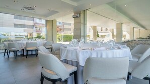 A modern dining area with tables set for service, large windows, and a view of the building's exterior. - Eurostars i-Hotel (Pozuelo de Alarcon)