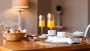 A breakfast setting with a basket of pastries, a cup of coffee, and two glasses of orange juice on a wooden table. - Hotel Fairplay Golf & Spa Resort-by Grupo Tribu (Benalup-Casas Vieja)