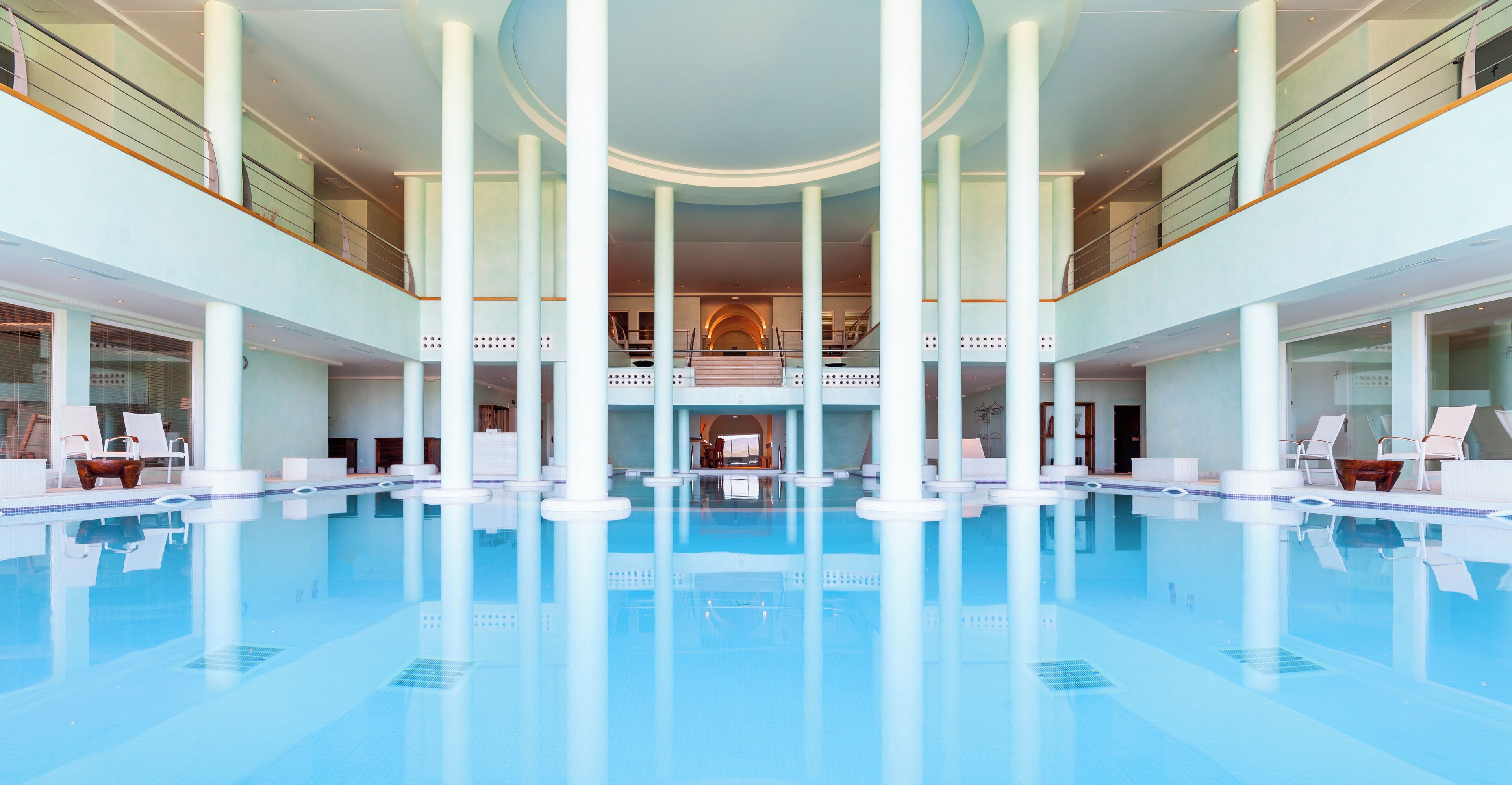 Una grande piscina coperta con diversi livelli e zone relax.