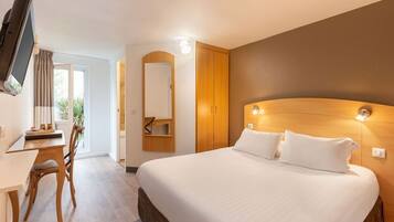 A hotel room with a bed, a desk, and a chair.