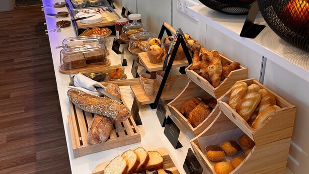 Un buffet proposant une variété de pains, de viennoiseries et de fruits.