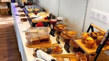 Un bufé con diversos alimentos y una barra larga.