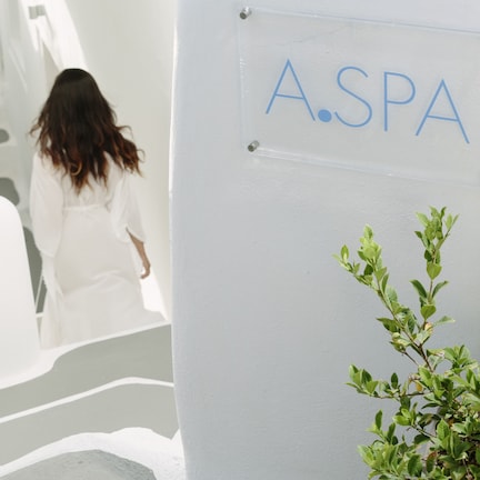 A person walking up a white staircase in a modern building with a sign reading "A.SPA".