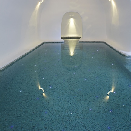 A swimming pool with a clear blue water surface and a curved ceiling.