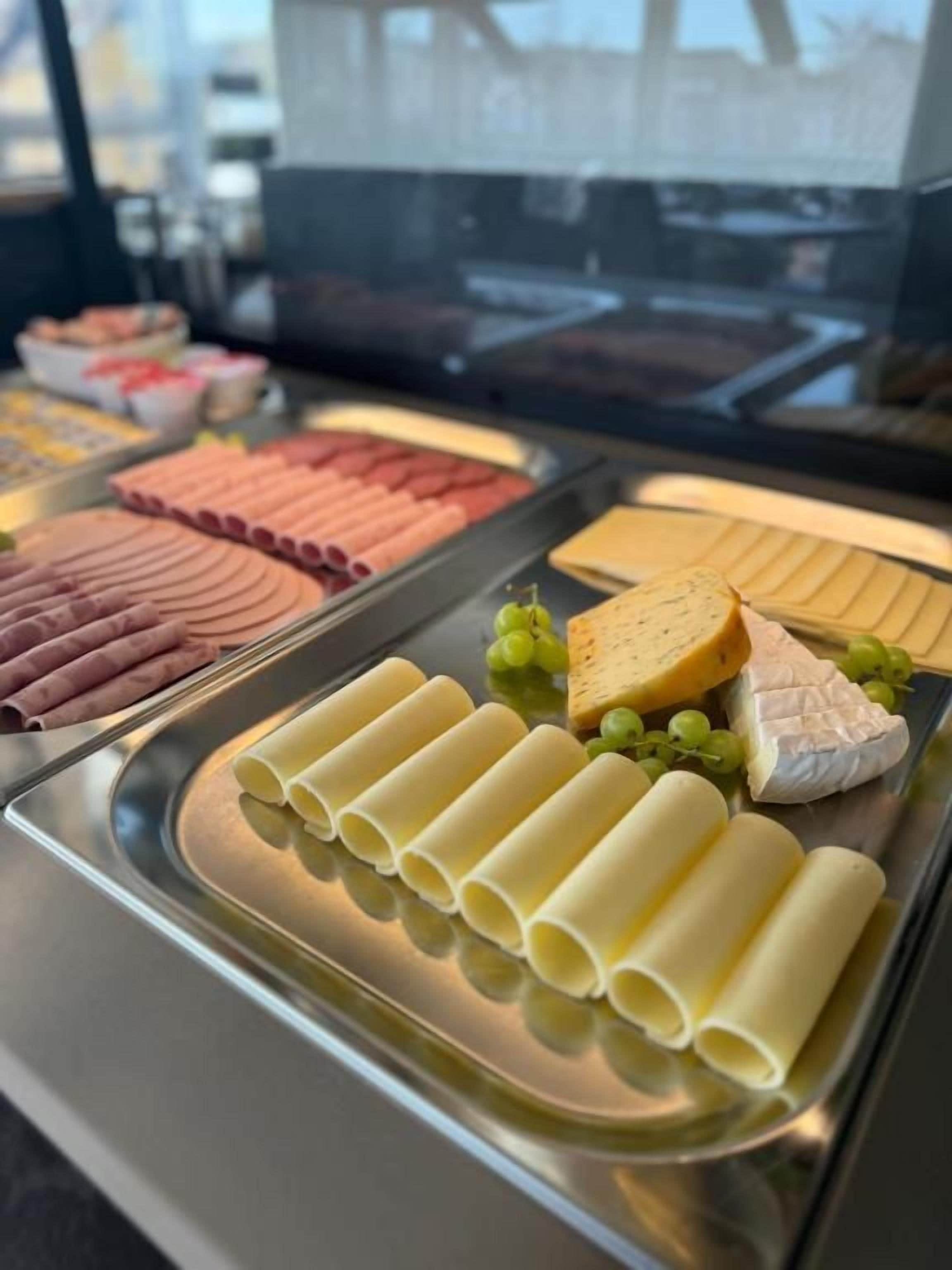 A selection of cheeses and cured meats on a display tray.