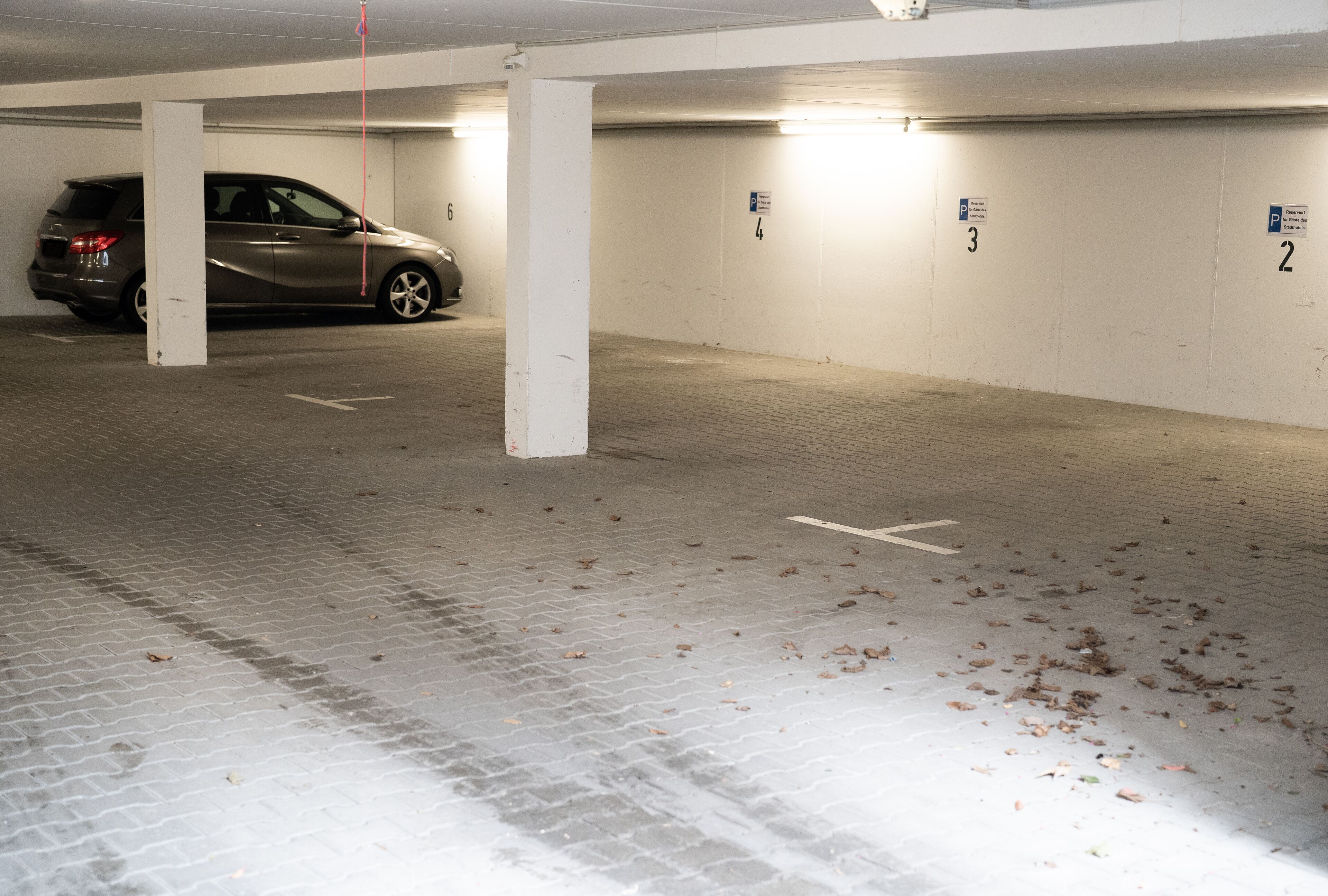 Un estacionamiento con espacios numerados y un coche estacionado en el espacio número 6.