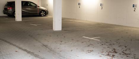 Un estacionamiento con espacios numerados y un coche estacionado en el espacio número 6.